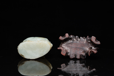 A Chinese celadon and russet jade ram sculpture on wooden stand, 19th C.