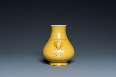 A Chinese monochrome yellow-glazed 'hu' vase on wooden stand, Qianlong mark, 19/20th C.