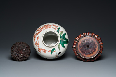 A Chinese famille verte jar with wooden cover and stand, 19th C.