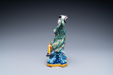 A polychrome Dutch Delft figure of a seated man and a blue and white one of a seated lady, 18th C.