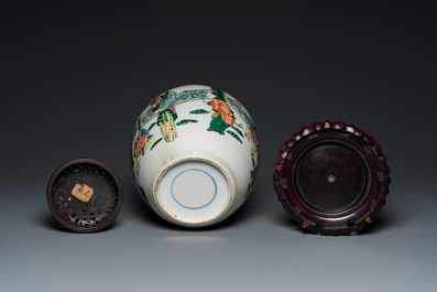 A Chinese famille verte jar with wooden cover and stand, 19th C.