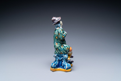 A polychrome Dutch Delft figure of a seated man and a blue and white one of a seated lady, 18th C.