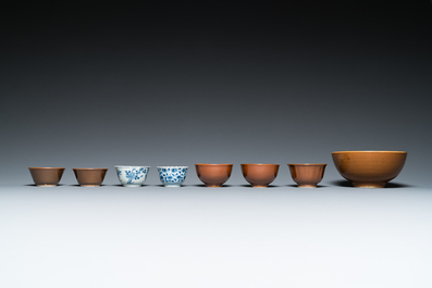 Eleven Chinese blue and white saucers, seven cups and a bowl, Kangxi/Qianlong