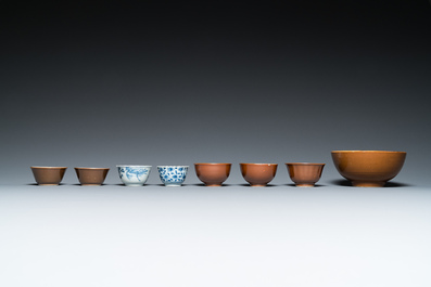 Eleven Chinese blue and white saucers, seven cups and a bowl, Kangxi/Qianlong