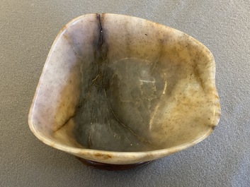 A Chinese hollowed jade libation cup on wooden stand, probably Qing