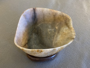 A Chinese hollowed jade libation cup on wooden stand, probably Qing