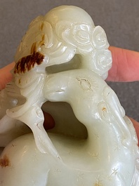 Een Chinese celadon-roest jade sculptuur van een ram op houten sokkel, 19e eeuw