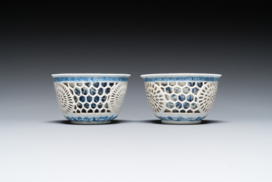 A pair of Chinese blue and white reticulated double-walled cups and saucers, Kangxi