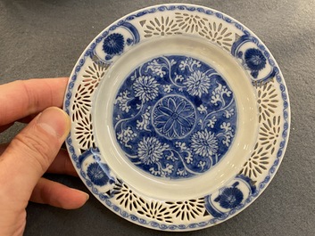 A pair of Chinese blue and white reticulated double-walled cups and saucers, Kangxi