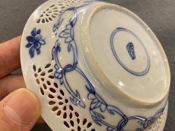 A pair of Chinese blue and white reticulated double-walled cups and saucers, Kangxi