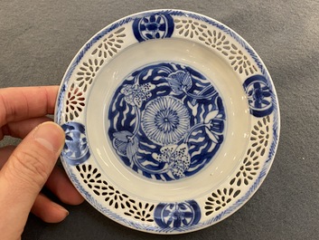 A pair of Chinese blue and white reticulated double-walled cups and saucers, Kangxi