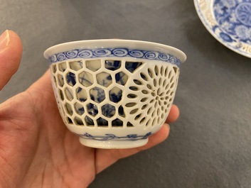 A pair of Chinese blue and white reticulated double-walled cups and saucers, Kangxi