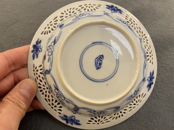 A pair of Chinese blue and white reticulated double-walled cups and saucers, Kangxi