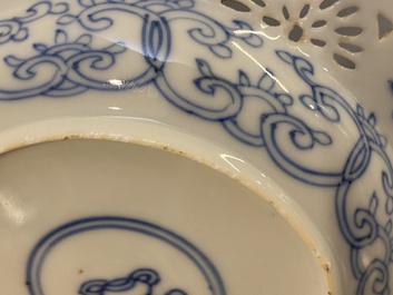 A pair of Chinese blue and white reticulated double-walled cups and saucers, Kangxi