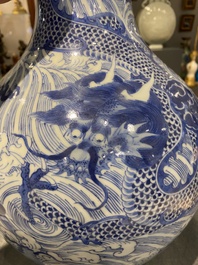 A Chinese blue and white 'dragons' bottle vase, 19th C.