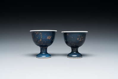 Een paar Chinese poederblauwe stem cups met verguld decor, Kangxi