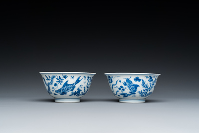 A pair of Chinese blue and white 'carps' cups and saucers, Kangxi