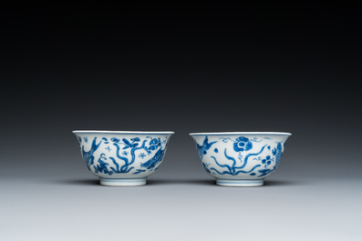 A pair of Chinese blue and white 'carps' cups and saucers, Kangxi