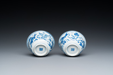 A pair of Chinese blue and white 'carps' cups and saucers, Kangxi