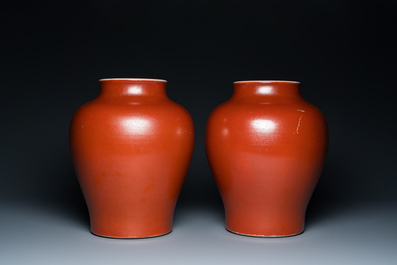A pair of Chinese monochrome coral-red-glazed vases with wooden stands and lids, Republic