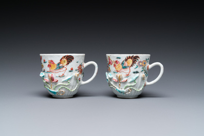 A pair of Chinese famille rose relief-decorated cups and saucers, Yongzheng