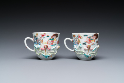 A pair of Chinese famille rose relief-decorated cups and saucers, Yongzheng