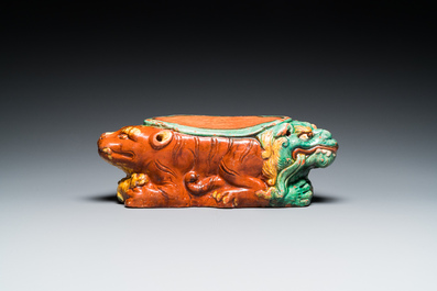 A Chinese sancai-glazed 'three lions' pillow or neck rest, Ming