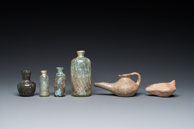 Quatre bouteilles en verre romain, deux lampes &agrave; huile et un bol en c&eacute;ramique