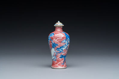 A Chinese blue, white and copper-red 'dogs' snuff bottle, 19th C.