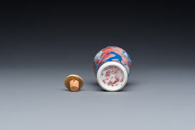 A Chinese blue, white and copper-red 'dogs' snuff bottle, 19th C.