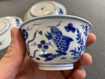 A pair of Chinese blue and white 'carps' cups and saucers, Kangxi