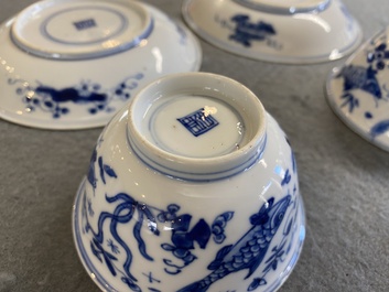 A pair of Chinese blue and white 'carps' cups and saucers, Kangxi