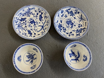 A pair of Chinese blue and white 'carps' cups and saucers, Kangxi