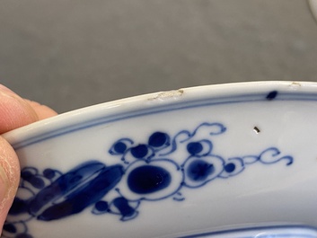 A pair of Chinese blue and white 'carps' cups and saucers, Kangxi