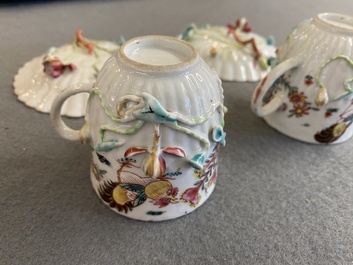 A pair of Chinese famille rose relief-decorated cups and saucers, Yongzheng