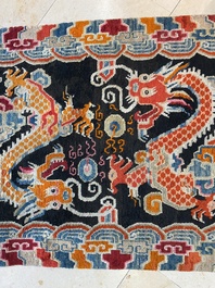 A Tibetan rug with two dragons chasing the pearl of wisdom, 19th C.