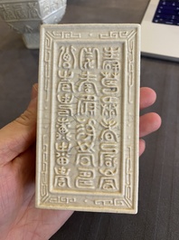 Een Chinese monochrome cr&egrave;mekleurige craquel&eacute; vaas en een penselenbeker met reli&euml;fdecor, Qing