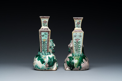 A pair of Chinese verte biscuit vases resting on Buddhist lions, Kangxi