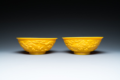 A pair of Chinese yellow Beijing glass bowls with figures in mountainous landscapes, 19/20th C.