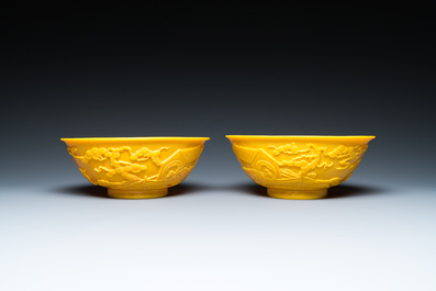 A pair of Chinese yellow Beijing glass bowls with figures in mountainous landscapes, 19/20th C.