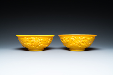 A pair of Chinese yellow Beijing glass bowls with figures in mountainous landscapes, 19/20th C.