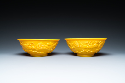 A pair of Chinese yellow Beijing glass bowls with figures in mountainous landscapes, 19/20th C.