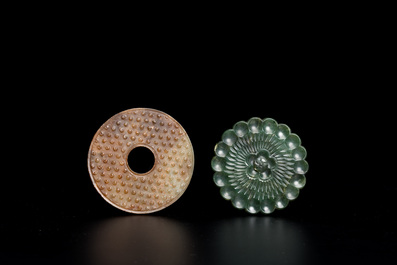 A Chinese celadon and russet jade 'bi' disc and a spinach green flower-shaped pendant on wooden stands, Ming and Qing