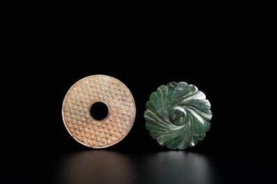 A Chinese celadon and russet jade 'bi' disc and a spinach green flower-shaped pendant on wooden stands, Ming and Qing