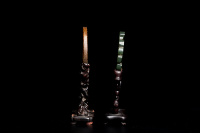 A Chinese celadon and russet jade 'bi' disc and a spinach green flower-shaped pendant on wooden stands, Ming and Qing