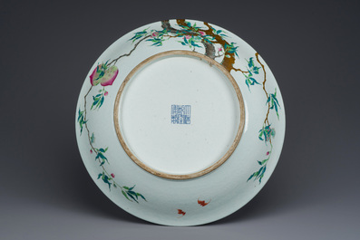 Grand plat en porcelaine de Chine famille rose &agrave; d&eacute;cor des 'neuf p&ecirc;ches', marque de Qianlong, 19&egrave;me