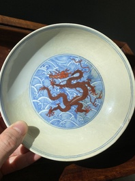 Paire de coupes en porcelaine de Chine &agrave; d&eacute;cor de dragons en rouge de fer sur fond de vagues en bleu et blanc, marque et &eacute;poque de Qianlong
