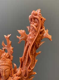 A Chinese red coral figure of a standing Guanyin with a dragon, 19/20th C.