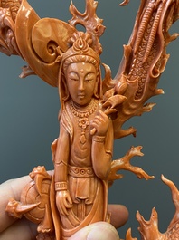 A Chinese red coral figure of a standing Guanyin with a dragon, 19/20th C.