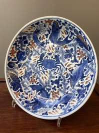 Plat en porcelaine de Chine en bleu, blanc et rouge de cuivre &agrave; d&eacute;cor de poissons et d'un crabe, Kangxi